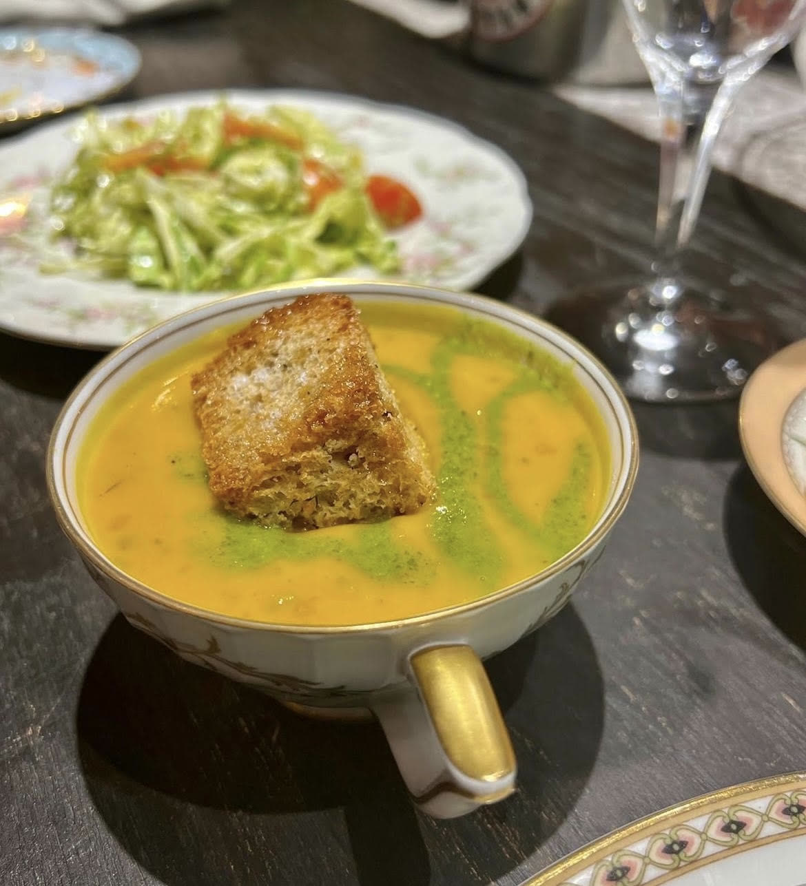 Soup served in a vintage teacup with a crouton