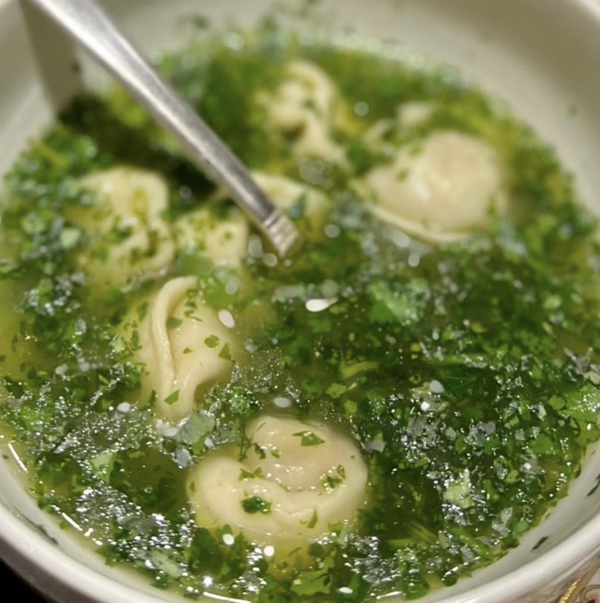 Herb broth with dumplings, finished tableside