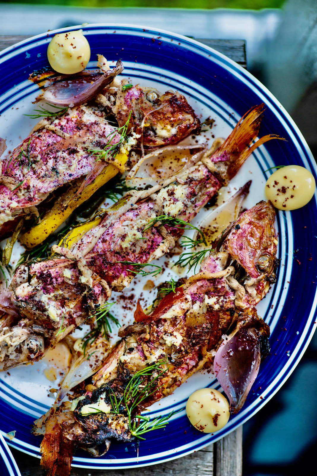 Whole grilled fish plated with citrus and herbs