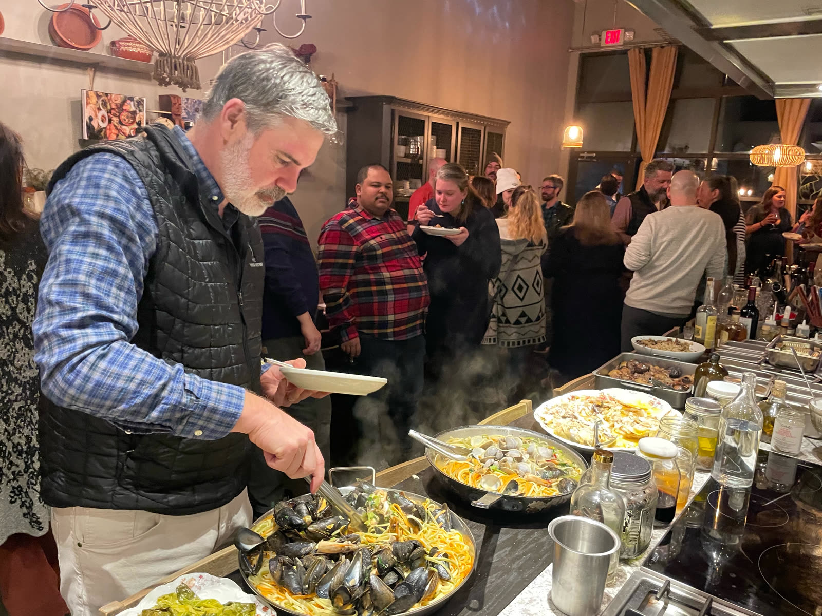 Chef plating pasta at the buffet counter