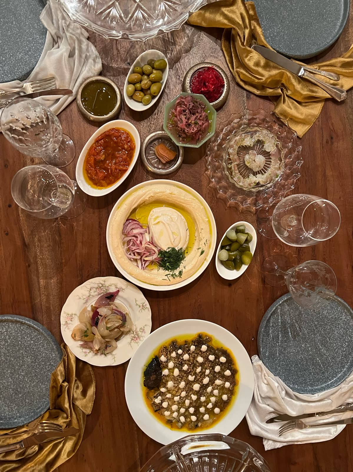 Overhead spread of mezze: hummus, olives, ceviche, and pickles