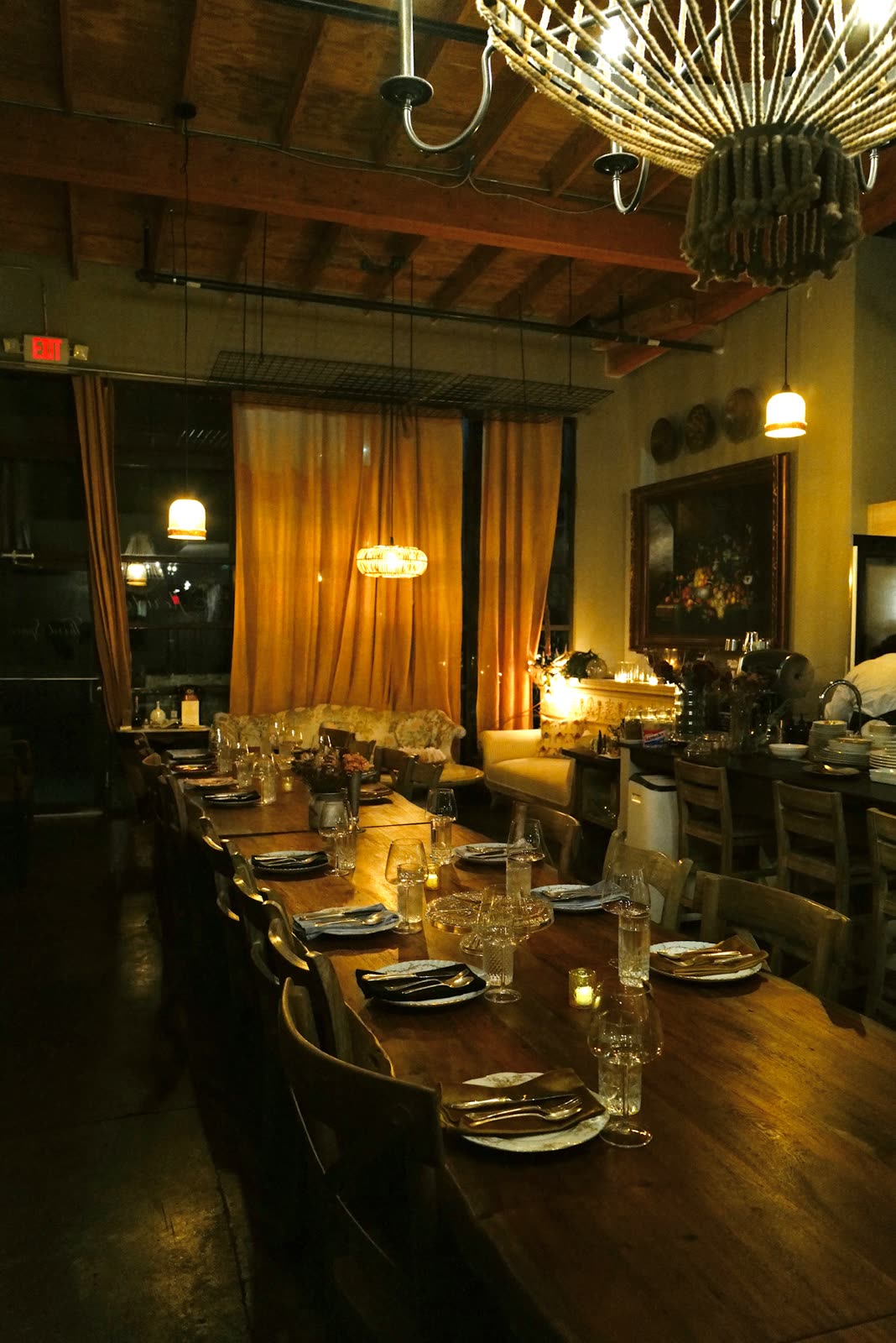 The dining room set for service, warm curtains and candlelight