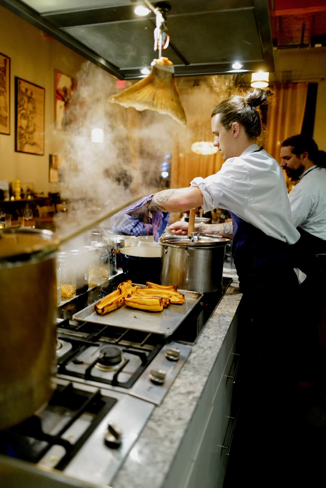 Chef at the stove finishing a dish tableside