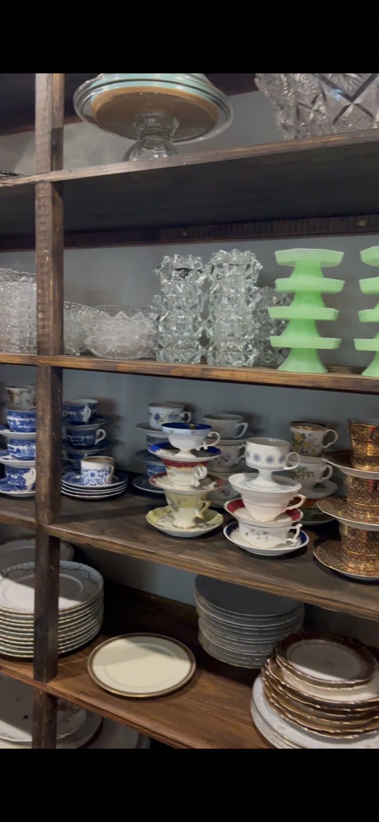 Vintage china and glassware on display shelving
