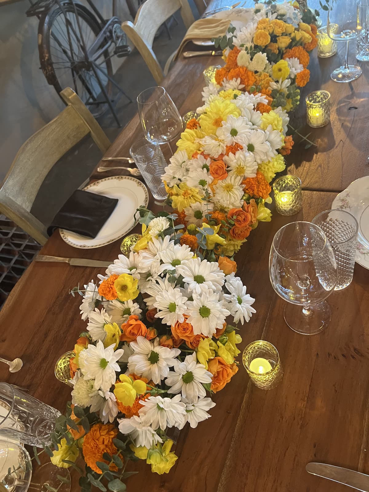 Overhead view of a long floral table runner with candlelight